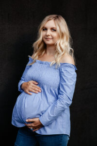 Przyszła mama uśmiecha się podczas spaceru po okolicy Służewskiego Domu Kultury.