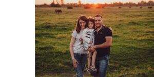 Dzieci bawią się radośnie wśród zieleni, w naturalnym geście.