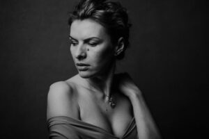 Kobieta pozuje po metamorfozie w eleganckiej, biznesowej stylizacji.