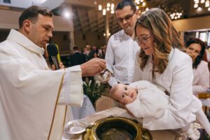 Uroczysty moment polewania główką dziecka wodą święconą podczas sakramentu Chrztu Świętego w Kobyłce