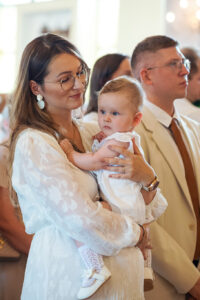 Rodzinne zdjęcie pamiątkowe przed kościołem po uroczystości Chrztu Świętego, profesjonalny fotograf Kobyłka